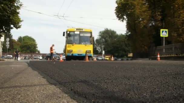 The trolleybus goes around the chips. Laying asphalt on the road. Road works. Traffic jams — Vídeo de stock