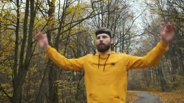 Brutale man doet een warming-up in het herfstpark. Dieet, sport en gezonde levensstijl — Stockvideo