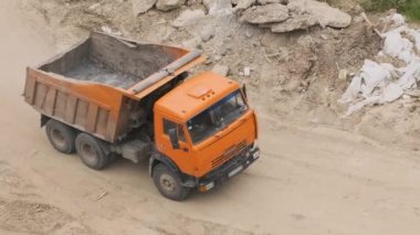 Bir kamyon malzeme yüklemek için inşaat alanından geçiyor..