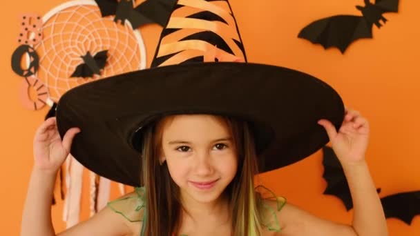 Милая Красивая Очаровательная Девушка Костюме Ведьмы Снимает Шляпу Хэллоуин Оранжевый — стоковое видео