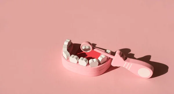 Model Ludzkiej Szczęki Lustrem Dentystycznym Odbijającym Ząb Różowym Tle Studia — Zdjęcie stockowe