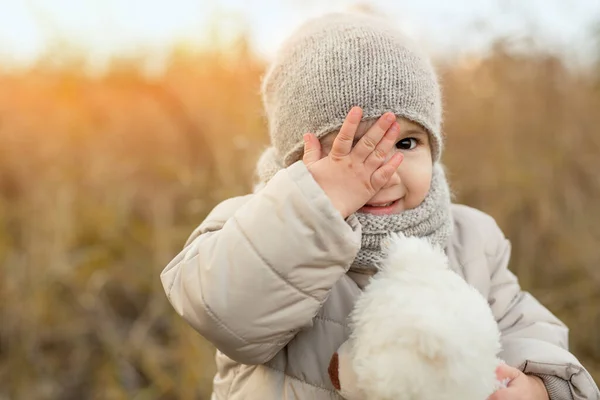 부드러운 장난감을 아이가 손으로 상냥하게 미소를 가을에 자연적으로 아이의 모습을 — 스톡 사진
