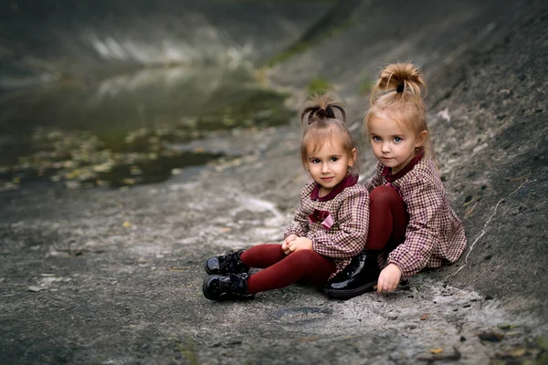 Friendship Two Little Girls Two Sisters Burgundy Dresses Sit Rocks — Stock Photo, Image