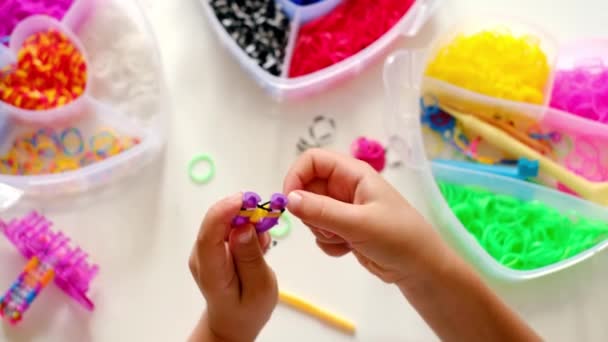 Kid Puts Rubber Bands Slingshot Braided Bracelet Crocheted Hands Close — Stock Video