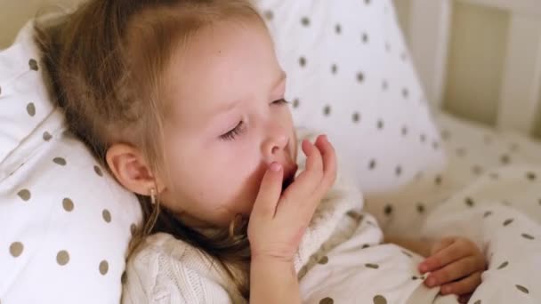 病気の1歳の子供はベッドに横たわって激しく咳をし 攻撃中に手で彼女の口を覆います 子供の季節性ウイルスや感染症 Covid 19隔離 — ストック動画