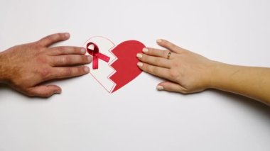 Kalp iki parçaya ayrılır ve yarısının üzerinde kırmızı bir kurdele bulunur. Dünya AIDS Farkındalık Günü. Aile hastalıktan dolayı bölündü.