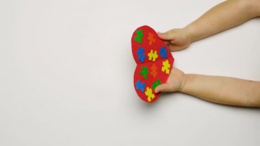 Çocuk otizm sendromlu çocuğa elini uzatıyor ve destek işareti olarak bileğini sıkıyor. Çocuklara nazik olmayı, duyarlı olmayı ve ihtiyacı olanlara yardım etmeyi öğret. Otizm Günü konsepti