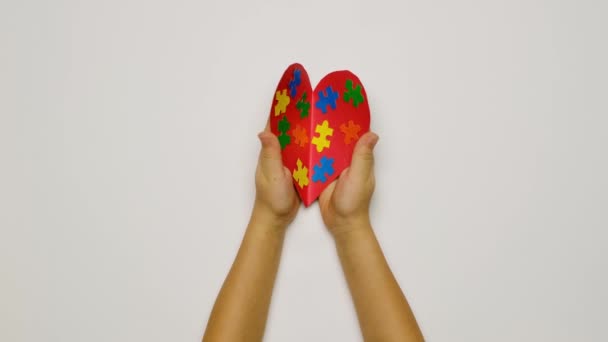 Kalp Şeklinde Bir Kartpostal Üzerinde Bulmaca Parçaları Olan Bir Çocuk — Stok video