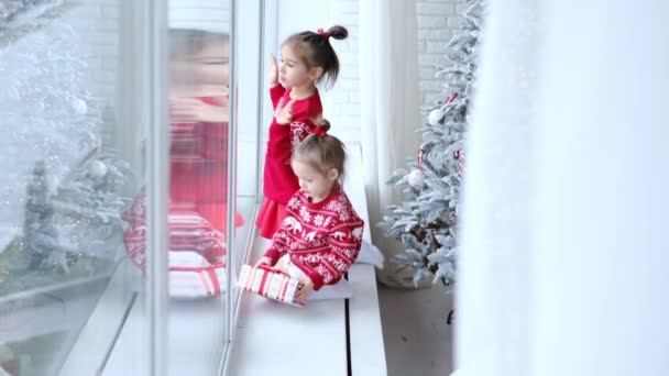 Dzieci Świątecznych Swetrach Siedzą Parapecie Rysują Palcami Szybie Która Jest — Wideo stockowe