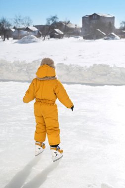 Çocuk kırsaldaki donmuş bir gölün buz pateni pistinde kayıyor. Bir çocuk açık havada güneşli bir günde paten kaymayı öğrenir. Kış tatillerinde ilginç bir eğlence..
