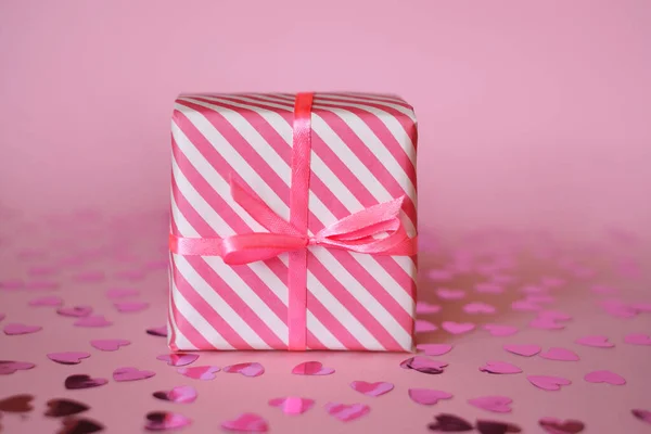 在情人节和生日那天 用粉红白色的小包装 系上缎带和白色背景的蝴蝶结 并为心爱的女人配上五彩纸屑的礼物 — 图库照片
