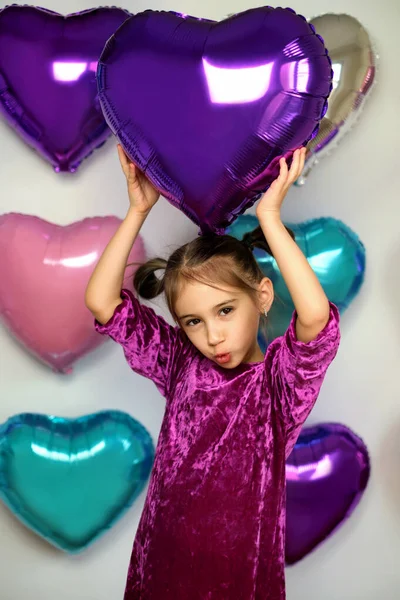 Una Chica Sostiene Globo Morado Forma Corazón Sobre Cabeza Sonriendo —  Fotos de Stock