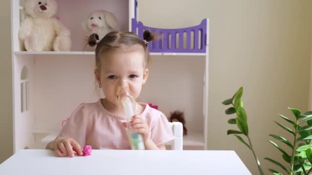 かわいい子供は部屋のテーブルに座っている間 マスクを通して吸入器から蒸気を呼吸します 喘息症状の軽減 咳の発作と肺炎の治療のための薬と吸入 — ストック動画