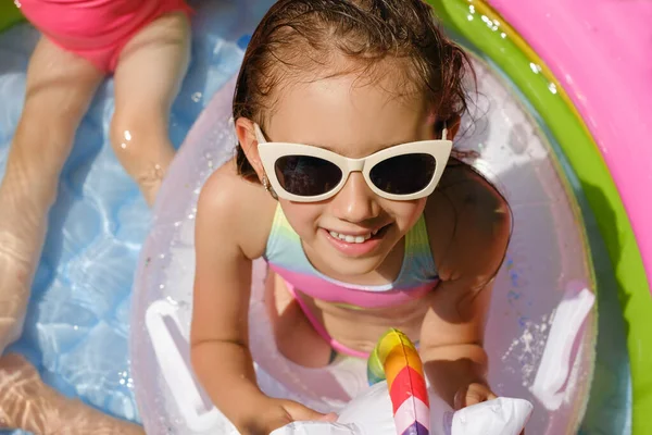 수영복을 선글라스를 아이는 뜨거운 햇볕을 받으며 부풀어 오르는 수영장에 소녀는 스톡 이미지