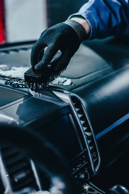 Eldivenli tamirci, yakın çekimde kanalın tozunu temizliyor.