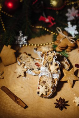 Tahta arka planda çalınmış bir Noel. Geleneksel Noel Almancası, Avrupa bayramı tatlısı. Kurumuş meyveli Noel pastası, Noel ağacının arka planında zencefilli kurabiye