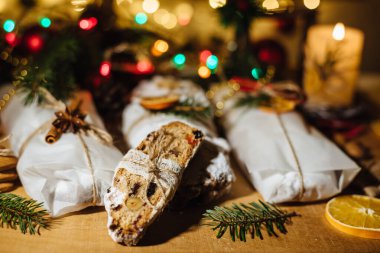 Tahta arka planda çalınmış bir Noel. Geleneksel Noel Almancası, Avrupa bayramı tatlısı. Kurumuş meyveli Noel pastası, Noel ağacının arka planında zencefilli kurabiye
