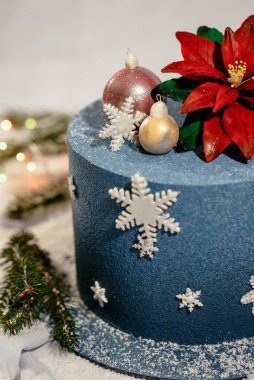 Yeni yıl tarzında dekore edilmiş lezzetli mavi pasta. Küreler ve kar taneleriyle süslenmiş Noel pastası. Yeni yıl tatlısı.