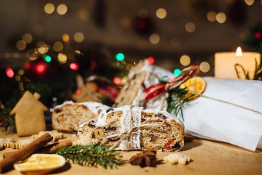 Tahta arka planda çalınmış bir Noel. Geleneksel Noel Almancası, şenlikli tatlı. Kurutulmuş meyveli Noel pastası, Noel ağacının arka planında zencefilli kurabiye. Seçici odak