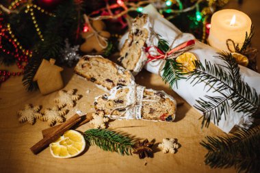 Tahta arka planda çalınmış bir Noel. Geleneksel Noel Almancası, şenlikli tatlı. Kurutulmuş meyveli Noel pastası, Noel ağacının arka planında zencefilli kurabiye. Seçici odak