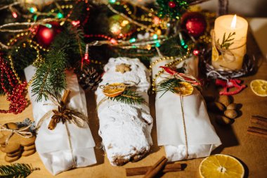 Tahta arka planda çalınmış bir Noel. Geleneksel Noel Almancası, şenlikli tatlı. Kurutulmuş meyveli Noel pastası, Noel ağacının arka planında zencefilli kurabiye. Seçici odak