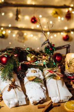 Tahta arka planda çalınmış bir Noel. Geleneksel Noel Almancası, şenlikli tatlı. Kurutulmuş meyveli Noel pastası, Noel ağacının arka planında zencefilli kurabiye. Seçici odak