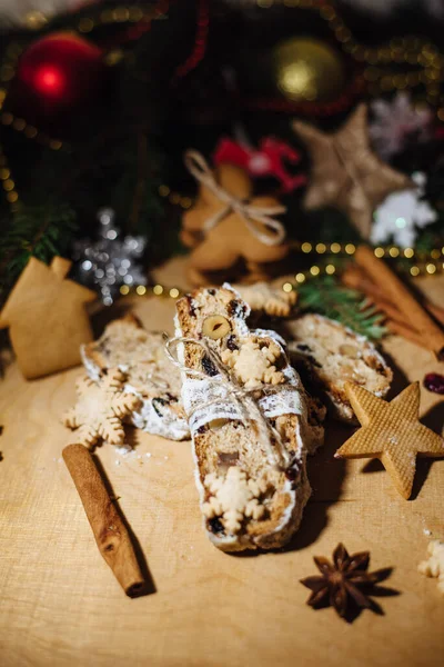 Tahta arka planda çalınmış bir Noel. Geleneksel Noel Almancası, şenlikli tatlı. Kurutulmuş meyveli Noel pastası, Noel ağacının arka planında zencefilli kurabiye. Seçici odak