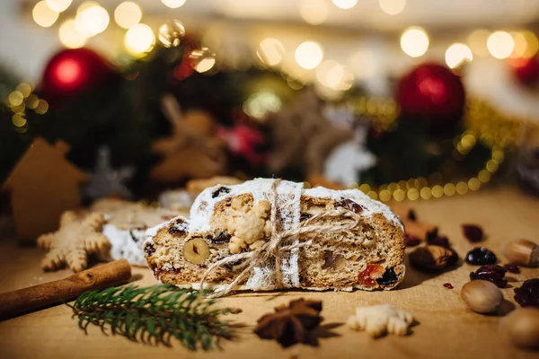 Tahta arka planda çalınmış bir Noel. Geleneksel Noel Almancası, şenlikli tatlı. Kurutulmuş meyveli Noel pastası, Noel ağacının arka planında zencefilli kurabiye. Seçici odak
