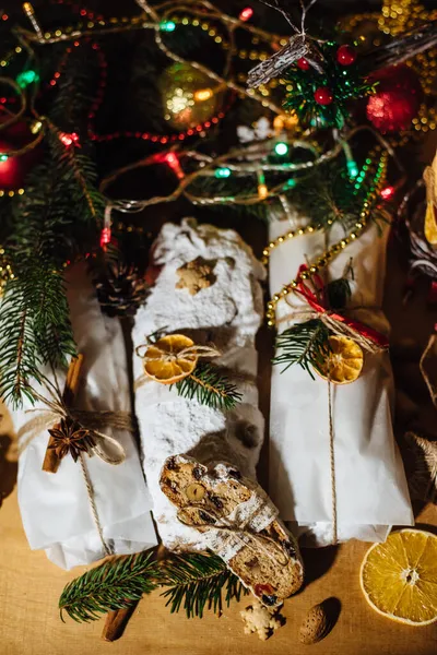 Tahta arka planda çalınmış bir Noel. Geleneksel Noel Almancası, şenlikli tatlı. Kurutulmuş meyveli Noel pastası, Noel ağacının arka planında zencefilli kurabiye. Seçici odak