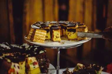 Bir insan eli açık büfe masasına pasta alır. Çikolata, Kek, Cheesecake