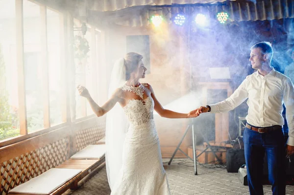 在他们第一次跳舞的时候 美丽的新婚夫妇站在浓烟中 新娘旋转着要和他一起在浓烟中跳舞 新娘和新郎在餐馆跳舞 新婚夫妇在浓烟中跳舞 薄膜颗粒 — 图库照片