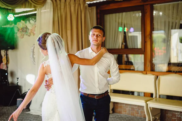 Gelin dumanın içinde dans ederken damada doğru kıvrılır. Gelin ve damat restoranda dans ediyor. Düğün çifti duman içinde dans ediyor.