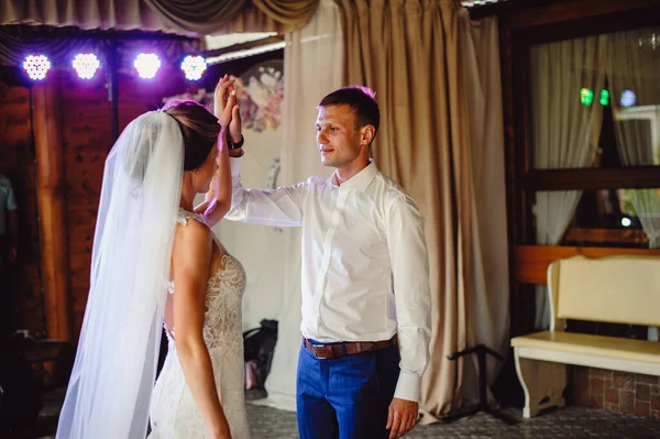 Gelin dumanın içinde dans ederken damada doğru kıvrılır. Gelin ve damat restoranda dans ediyor. Düğün çifti duman içinde dans ediyor.