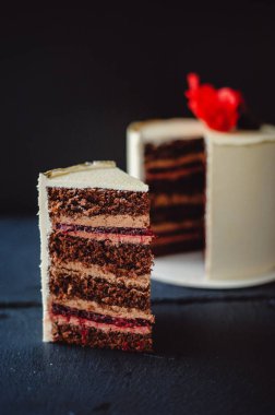 Koyu arkaplanda güzel bir çikolatalı pasta. Yakın plan. Kiraz reçelli çikolatalı kek. Dikey fotoğraf.
