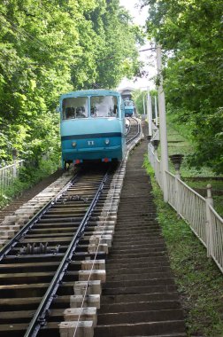 An old tram of blue color rides along the tracks. Narrow track of the railway. Logistics of rail transport. Children's Railway.