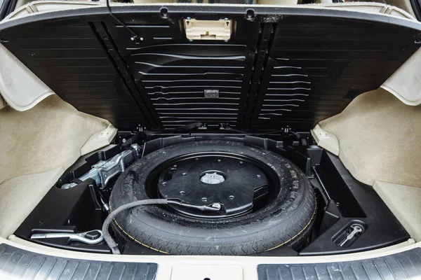 Spare wheel in the trunk of a modern car. Clean trunk of the SUV. Organization of space in the trunk