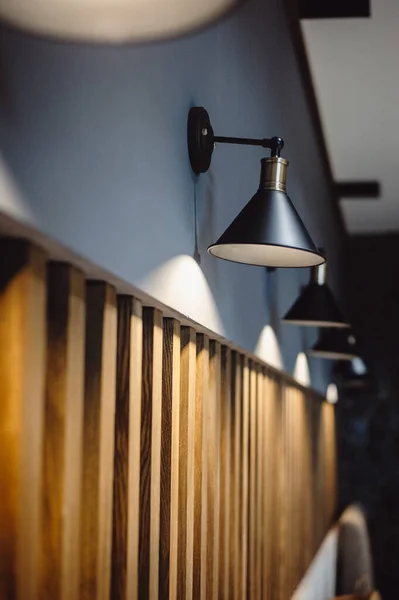Black lamps indicate a gray wall decorated with wooden lines, background for interior design. Interior decoration of stylish housing. Retro loft style lamp. Home design in a modern style. Film noise