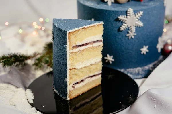 Delicious cream cake in cut. Festive Christmas cake decorated with spheres and snowflakes. New Year\'s dessert