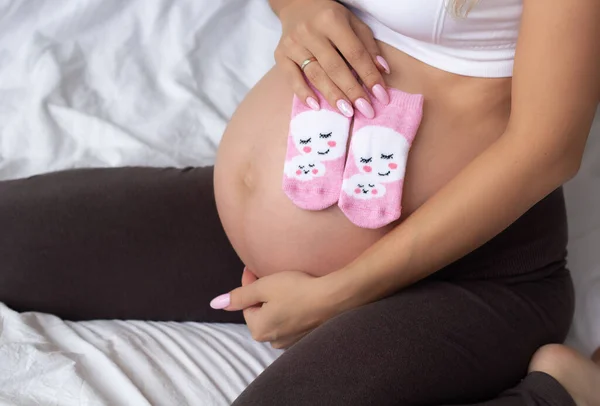 Roztomilá Blondýna Těhotná Dívka Sedí Doma Posteli Nosí Růžové Ponožky — Stock fotografie