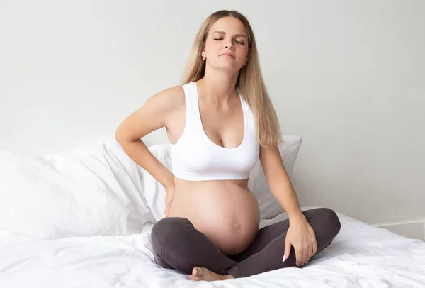 Krásná Blonďatá Těhotná Žena Sedí Posteli Zažívám Bolest Zad Problémy — Stock fotografie