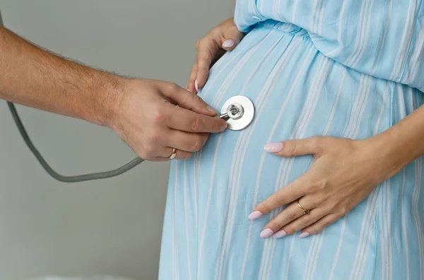 Muž Poslouchá Stetoskopem Břicho Těhotné Ženy Ruka Břicho Zblízka Mateřství — Stock fotografie