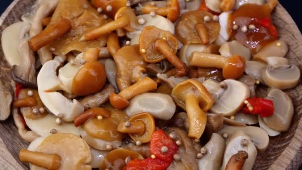 许多腌制的蜂蜜蘑菇撒满了各种香料豌豆，慢慢地在转盘上旋转. — 图库视频影像