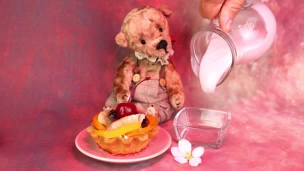 Sahne-Cupcake mit Kirschen, Beeren, Früchten und Apfelblüten auf rosa Hintergrund. Joghurt in durchsichtige Schüssel geben. — Stockvideo