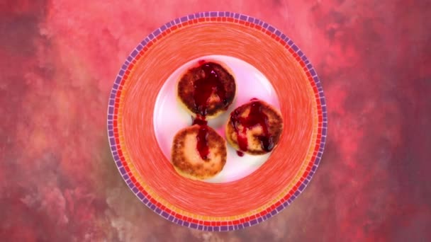 Tuang dengan selai cheesecake dengan keju cottage atau syrniki di atas piring berputar perlahan. — Stok Video