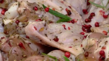 Baharatlı çiğ tavuk kanadı, kırmızı biber ve biberiye yavaşça döner. Hızlı bir tavuk aperatifi hazırlayın. Üst Manzara. Yakın plan..