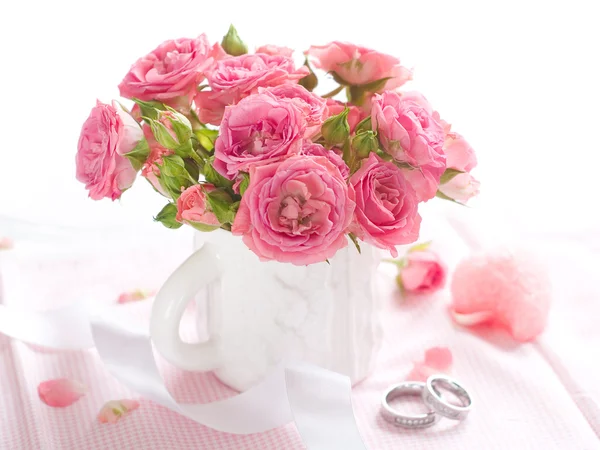 Růžové růže a snubní prsteny — Stock fotografie