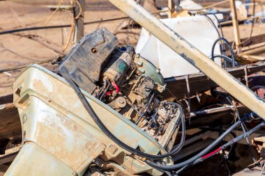 Photograph of a severely flood damaged boat outboard engine covered in dirt near the Hawkesbury river in New South Wales in Australia
