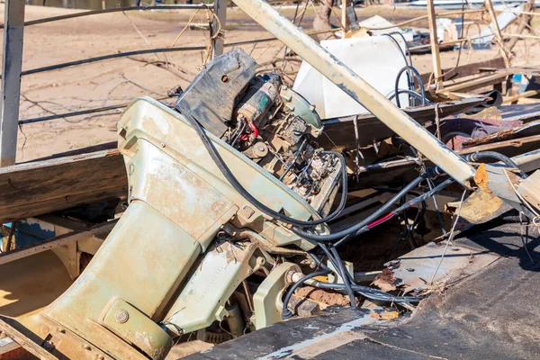 Photograph of a severely flood damaged boat outboard engine covered in dirt near the Hawkesbury river in New South Wales in Australia