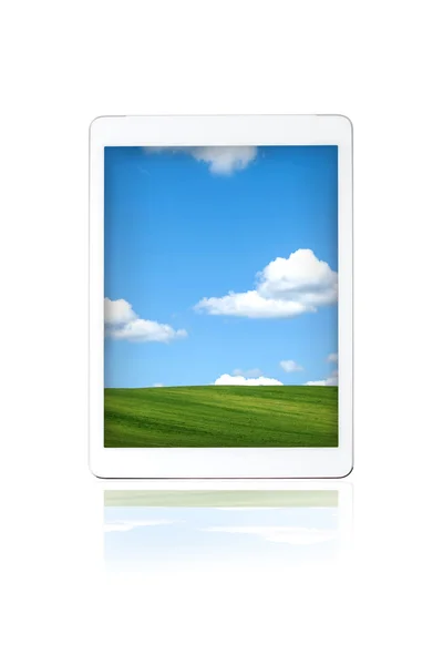 Louka s oblohou a mraky na obrazovku tabletu — Stock fotografie