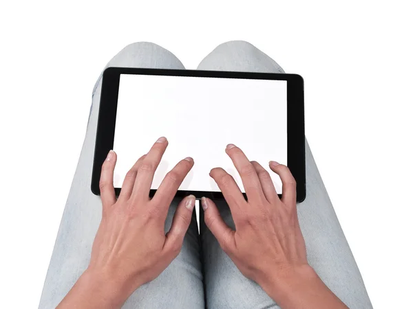 Woman writes on the tablet lying on the thighs Stock Picture